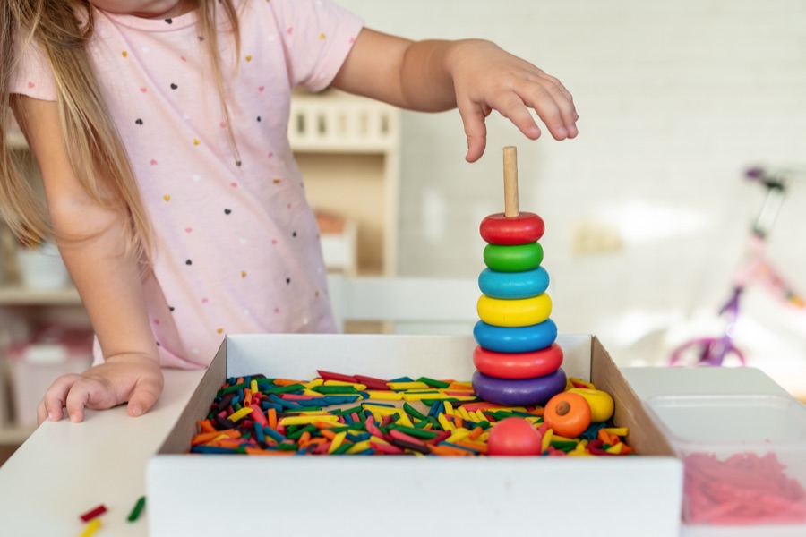 A child engaging calmly with colorful sensory toys