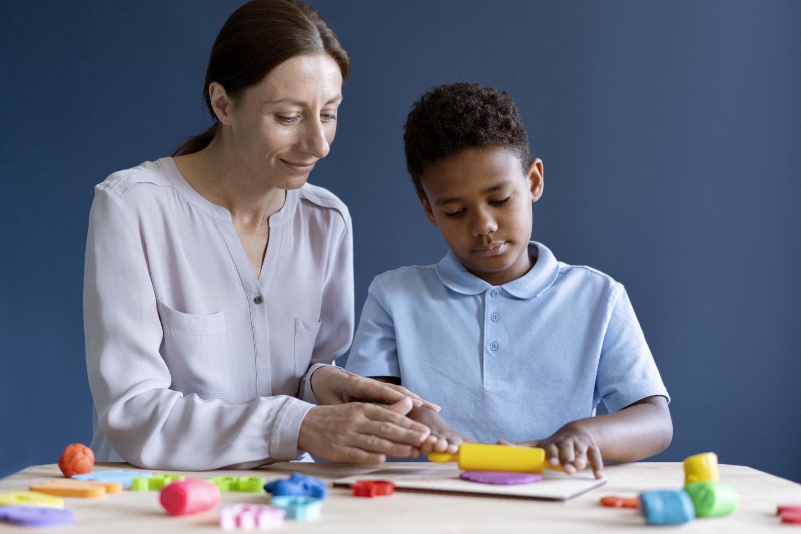 A boy working with a psychologist during an occupational therapy session