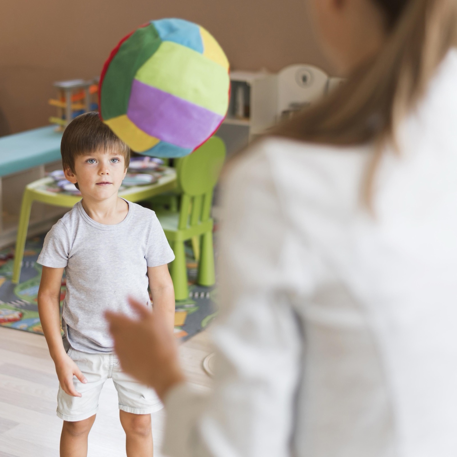 A teacher and a boy playing with a ball