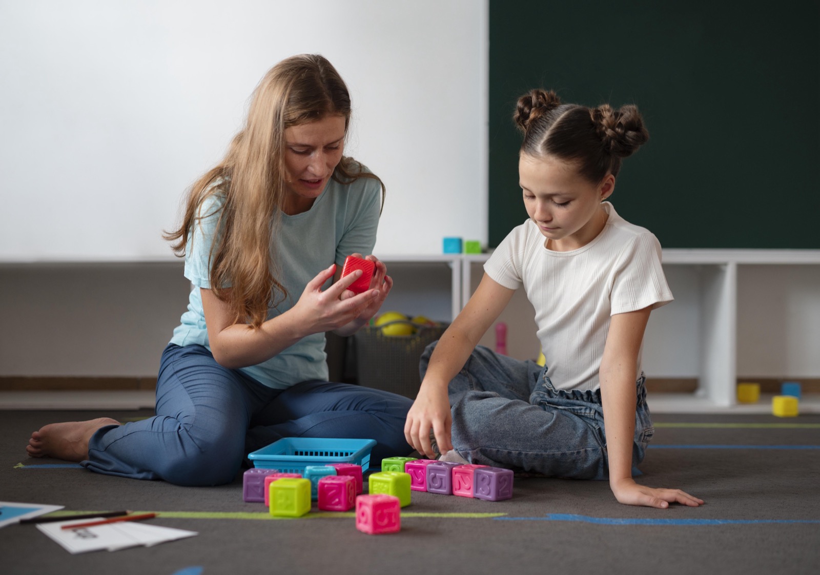 A psychologist helping a girl in speech therapy