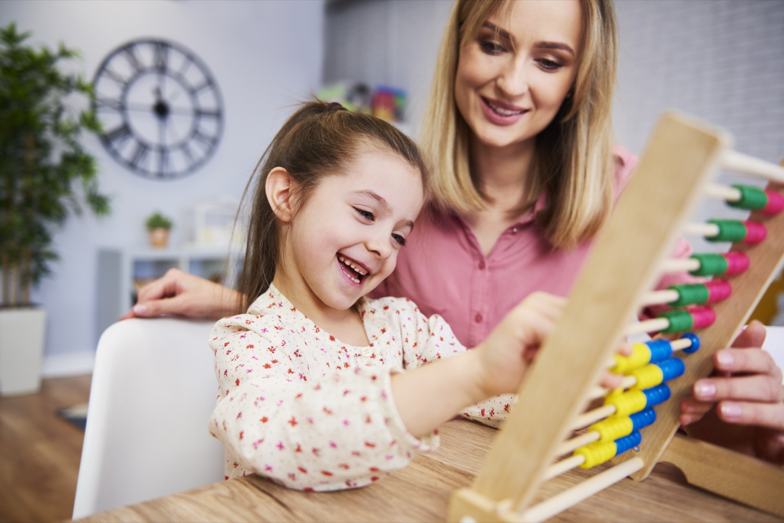 A girl and teacher using an abacus during homeschooling