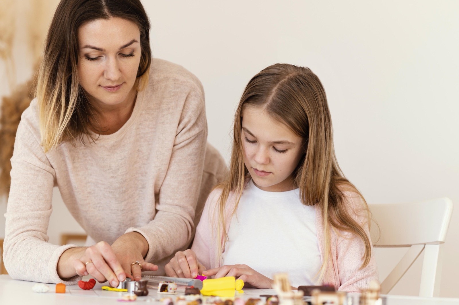 A woman and a girl playing with modeling clay