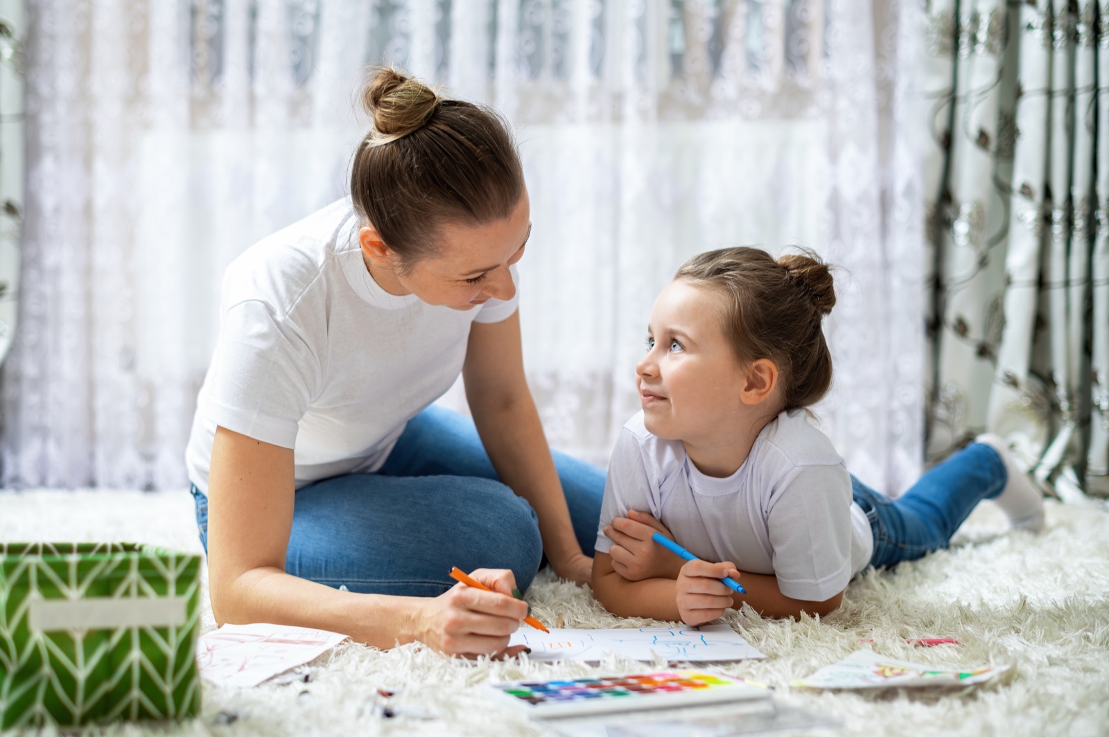 A mother and daughter playing together on the floor at home