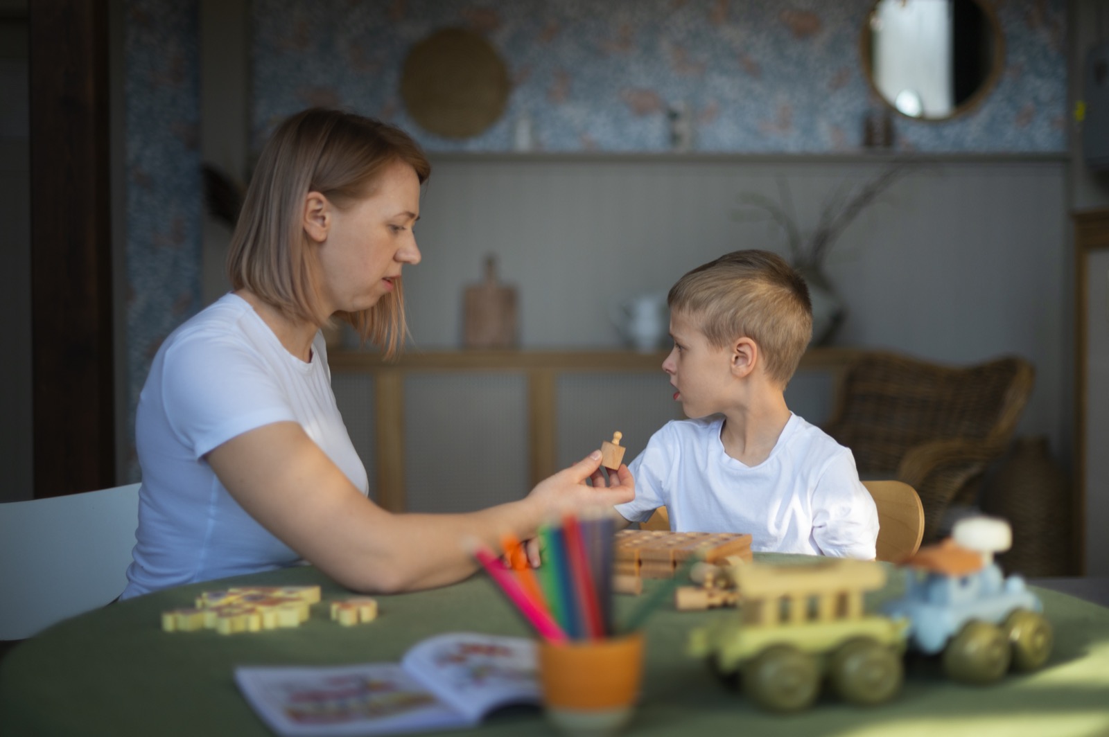 A mother playing with her autistic son using toys