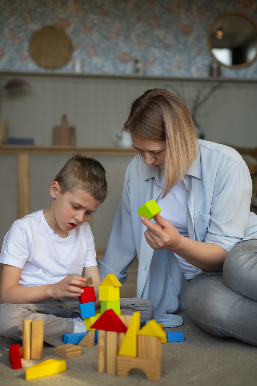 A mother playing with her autistic son using toys