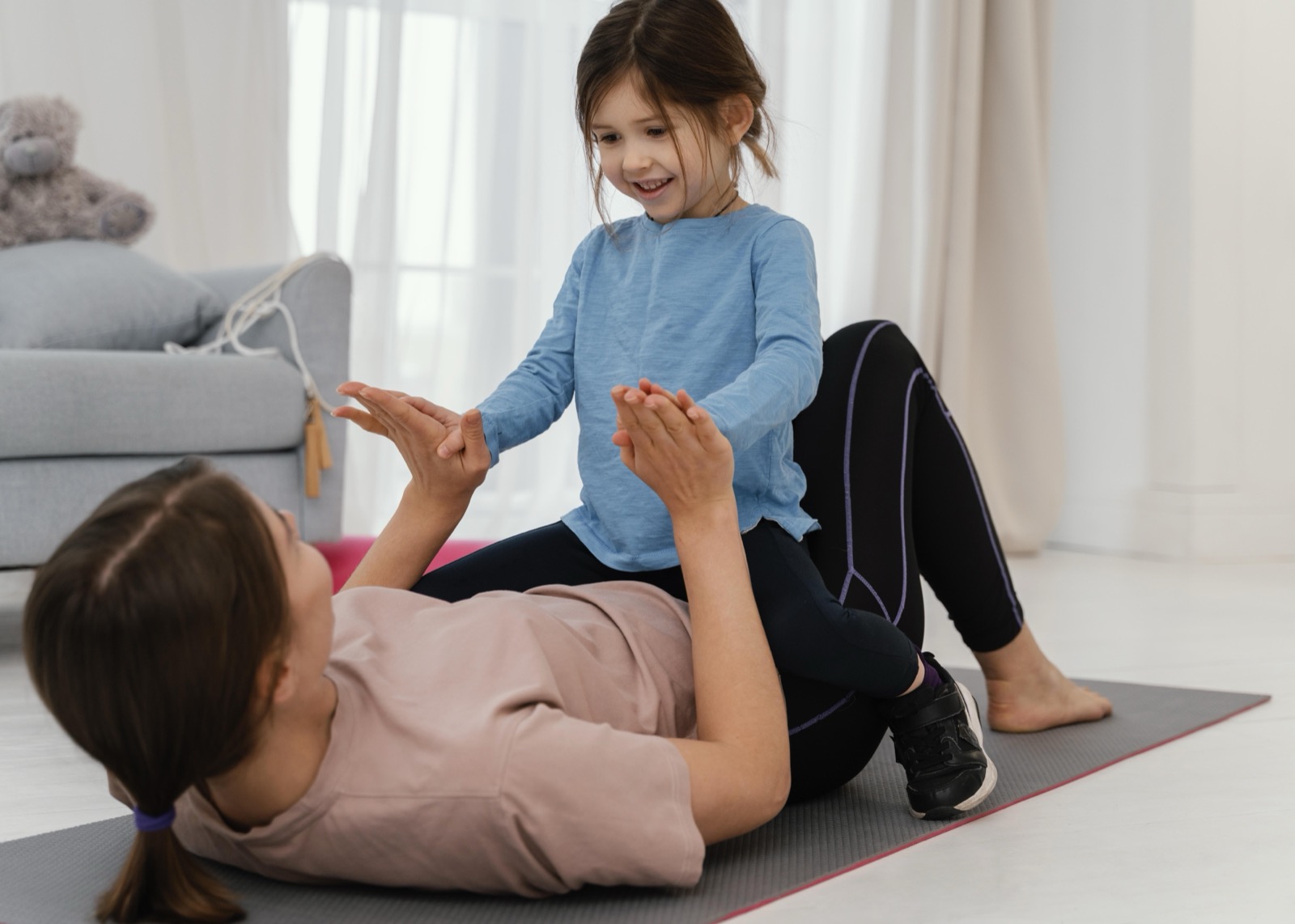 A mother doing a training exercise with her smiling child