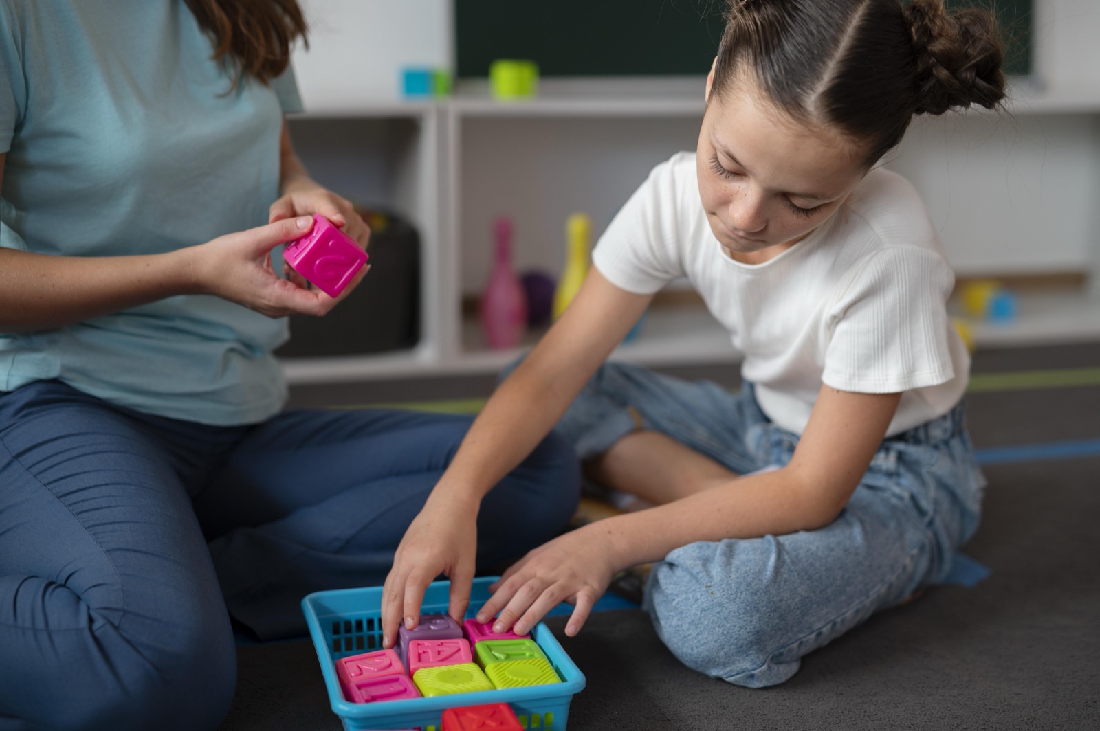A psychologist helping a girl in speech therapy indoors