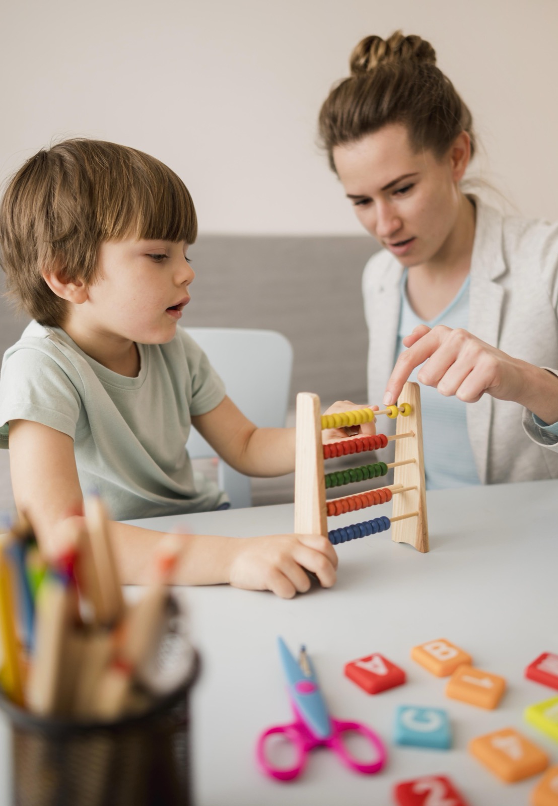 A tutor teaching a child how to use an abacus