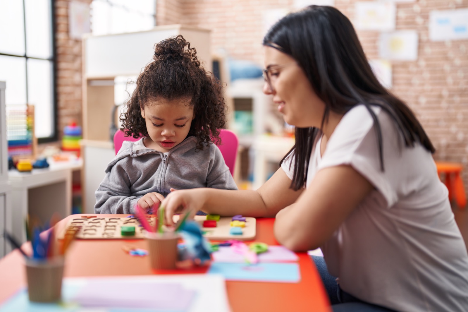 A teacher and toddler playing a maths puzzle game