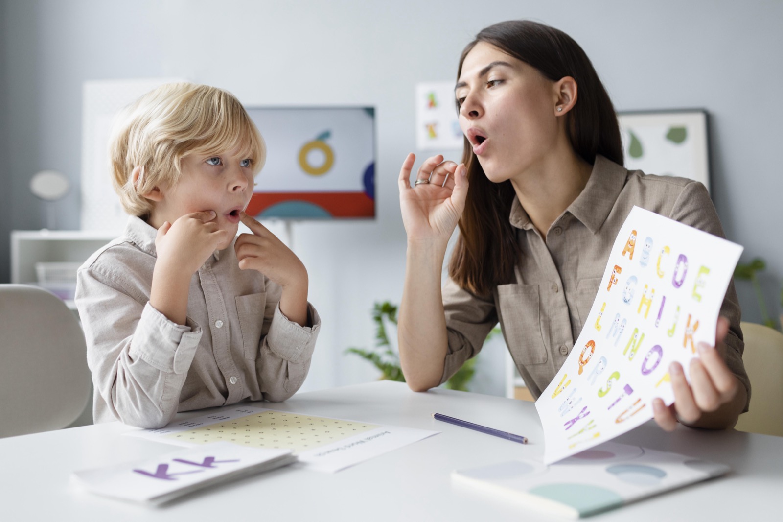 A therapist doing speech therapy with a young boy