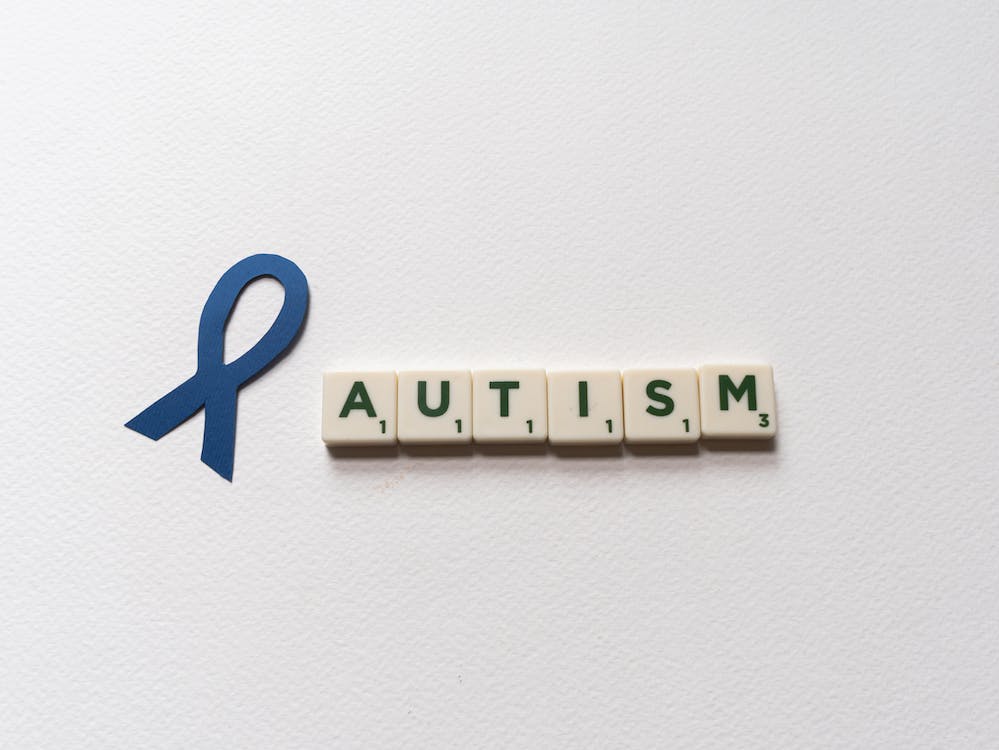 Free Letter Tiles beside a Blue Ribbon Cutout Stock Photo