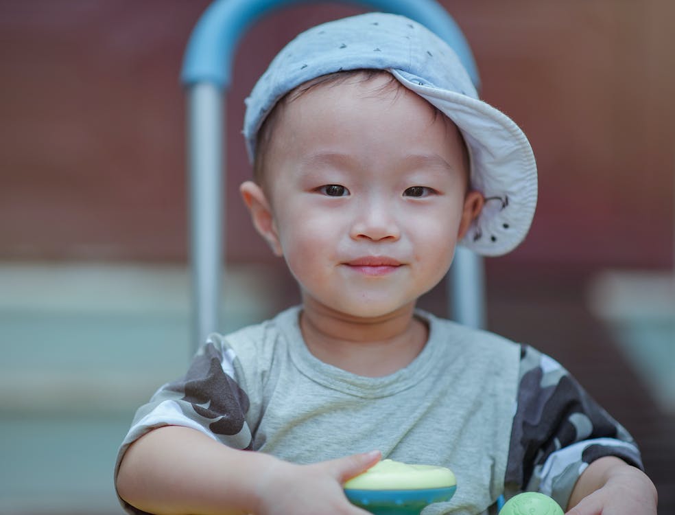 Free Depth of Field Photo of Boy Wearing Blue Cap Stock Photo