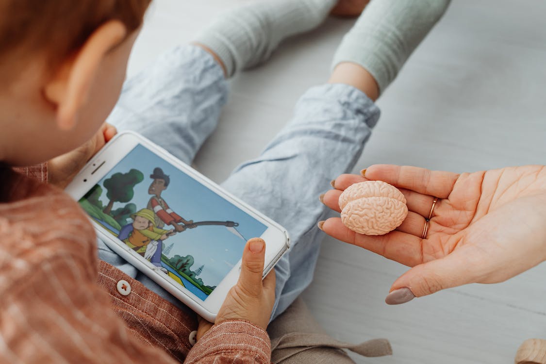 Free Photo of a Kid Watching on a Cell Phone Stock Photo
