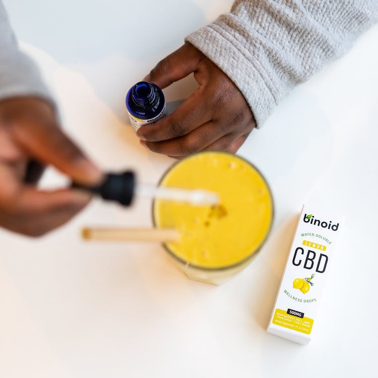 Free Person Holding A Dropper And Putting Medicine On A Drink Stock Photo