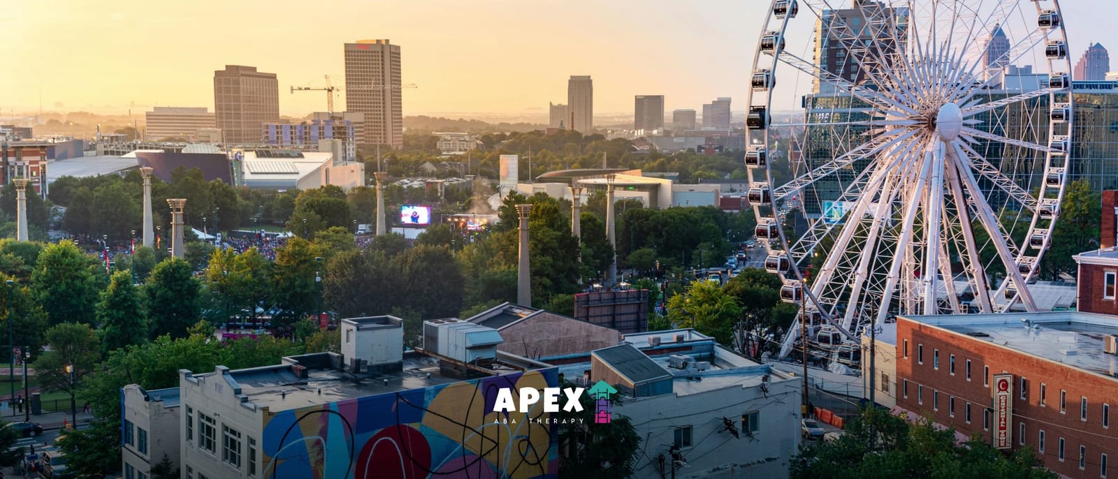 Aerial view of the Atlanta skyline at sunset with the SkyView Ferris wheel and Centennial Olympic Park in the foreground.